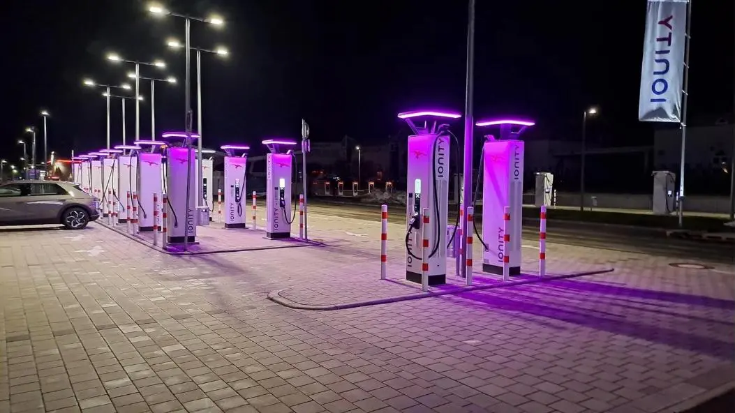 A row of illuminated fast chargers at night